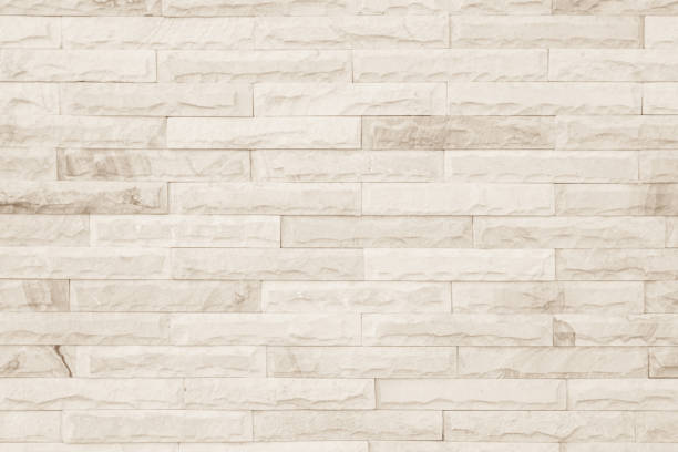 istock Empty background of wide cream brick wall texture. Beige old brown brick wall concrete or stone textured, wallpaper limestone abstract flooring/Grid uneven interior rock. Home decor design backdrop. 1327217957