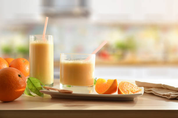 istock Orange milkshake with fruits on table kitchen background 1327220458