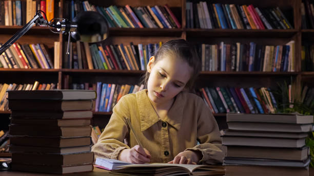 istock Concentrated girl in jacket writes homework in notebook 1327220797