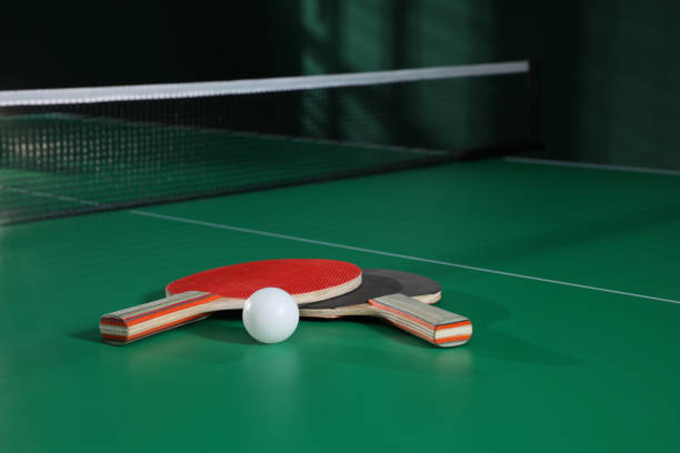 istock Rackets and ball on green ping pong table indoors. Space for text 1327221768