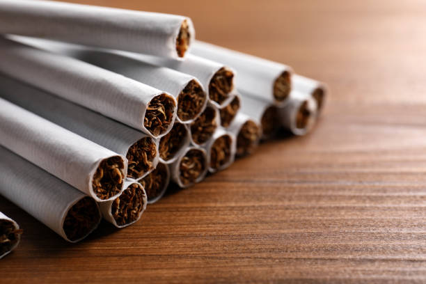 pile of cigarettes on wooden table, closeup - detrimental imagens e fotografias de stock