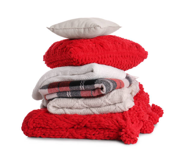 istock Stack of pillows and folded warm plaids on white background 1327221863