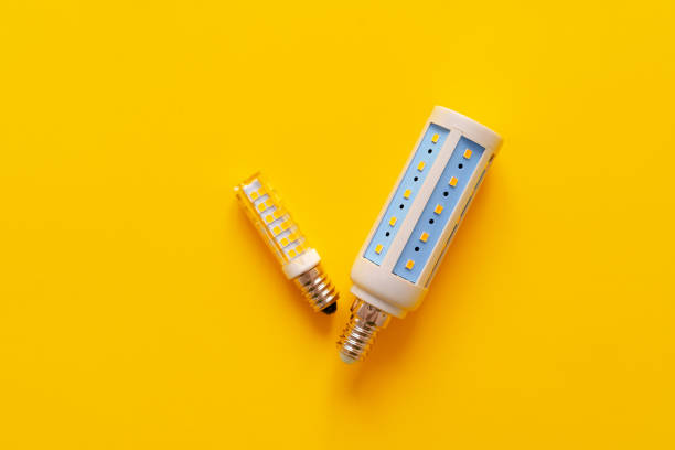 istock Light bulb on yellow paper background top view 1327222058
