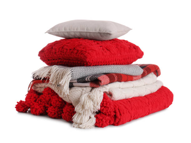 istock Stack of pillows and folded warm plaids on white background 1327222140