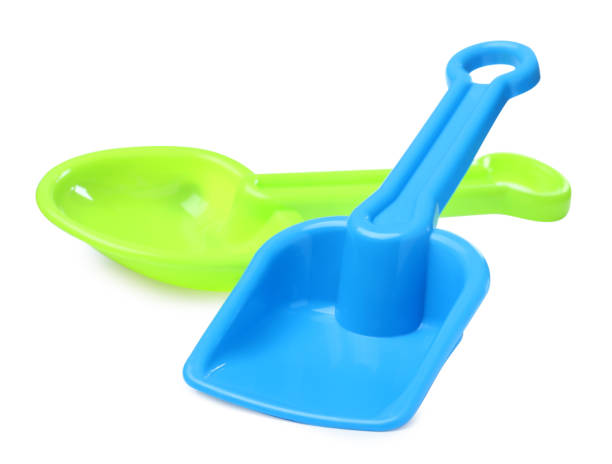 istock Green and light blue plastic toy shovels on white background 1327222185