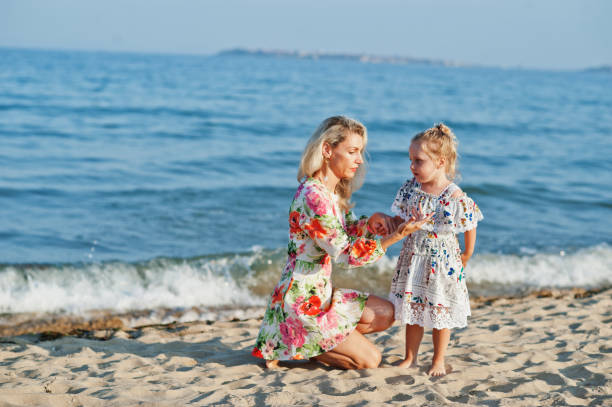 istock Mother and beautiful daughter having fun on the beach 1327226394
