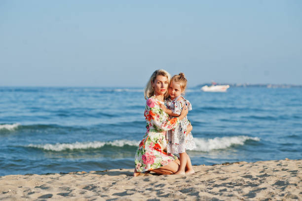 istock Mother and beautiful daughter having fun on the beach 1327226563