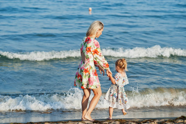 istock Mother and beautiful daughter having fun on the beach 1327226575