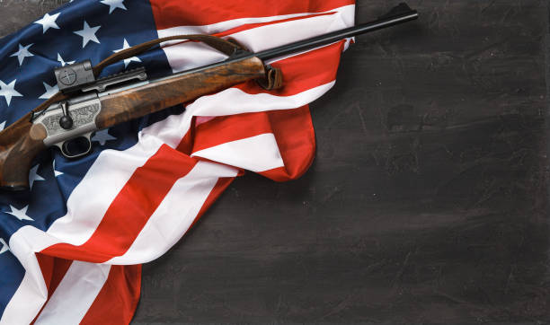 istock Automatic rifle on USA flag on wooden background 1327227139