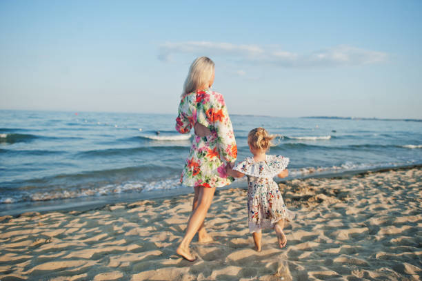 istock Mother and beautiful daughter having fun on the beach 1327227600