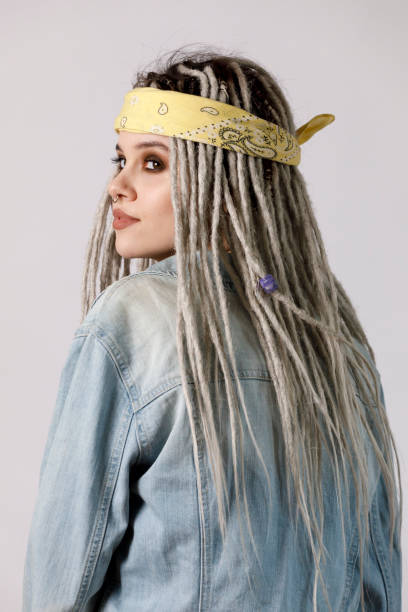 Portrait of a young stylish woman with dreadlocks on a light background. stock photo