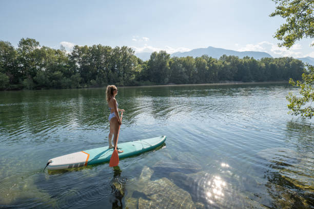 istock Woman paddling on a stand up paddle board 1327232247