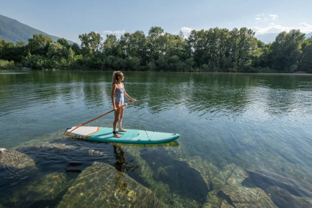 istock Woman paddling on a stand up paddle board 1327232368