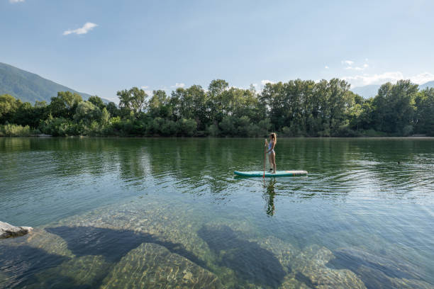 istock Woman paddling on a stand up paddle board 1327232393