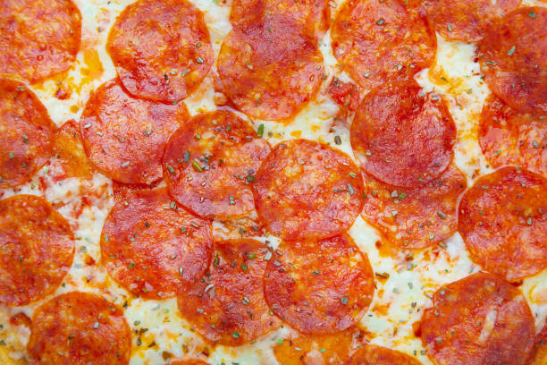 istock Appetizing bright pepperoni pizza closeup filling the frame. 1327235626