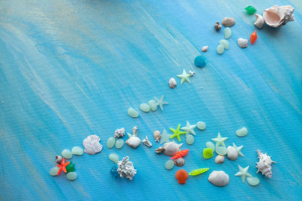istock Seashells summer background. Many different seashells, starfish on a background of turquoise paint strokes. Place for text 1327238464