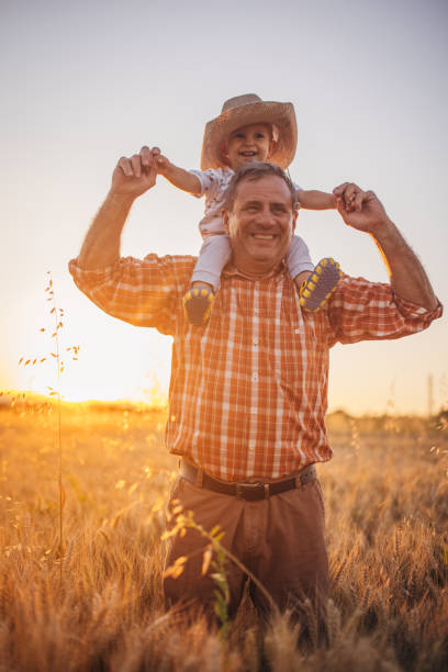 istock An older farmer in a grain field with his grandson 1327238688