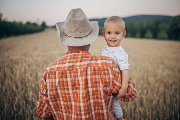 istock An old farmer is standing in a grain field 1327238842