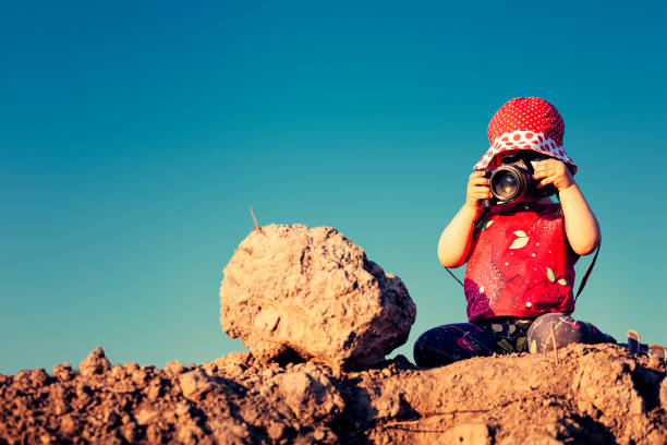 istock Little girl with a camera on a hill 1327240475