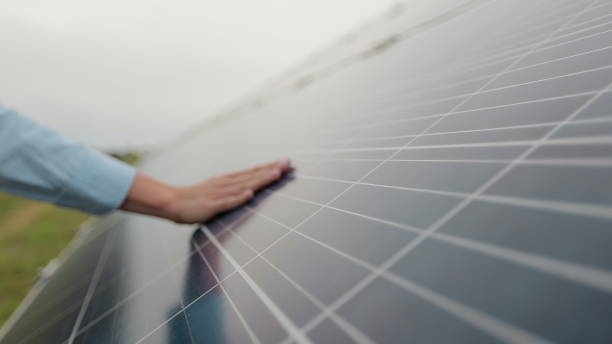 close up of a young woman engineer hand is checking the operation of sun and cleanliness of photovoltaic solar panels on a sunset. concept.renewable energy, technology, electricity, service, green. - solar panels house imagens e fotografias de stock
