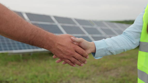istock Close up of handshake on solar panel background. Female engineer shakes hands with partner in agreement. Concept.renewable energy, technology, electricity, service, green. 1327242052