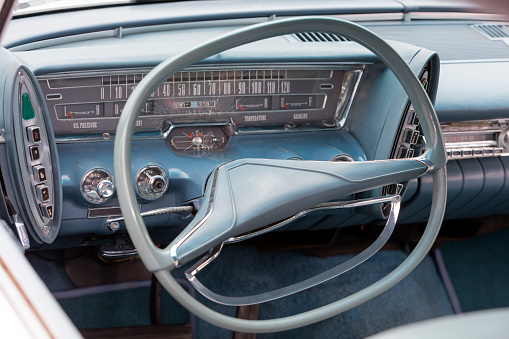 A side detail and interior of a blue stylish American classic car.