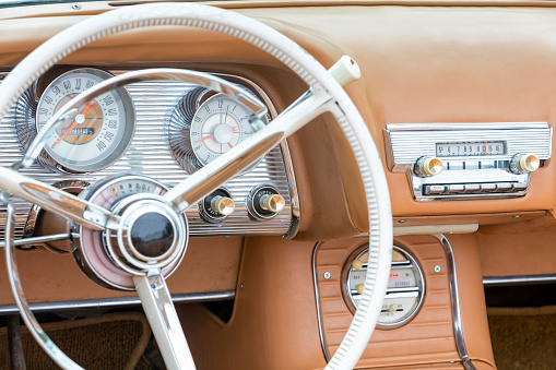 A side detail and interior of a brown stylish American classic car.