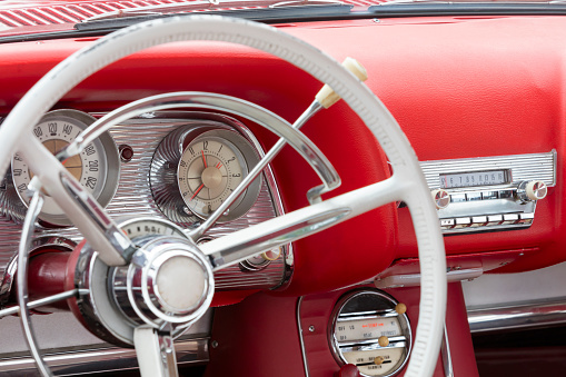 A side detail and interior of a red stylish American classic car.
