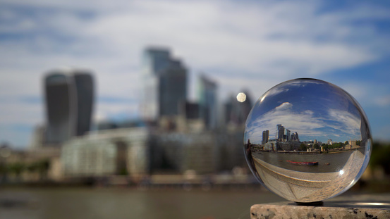2021 version of the towers and landmark buildings in the Square Mile refracted in a glass sphere.