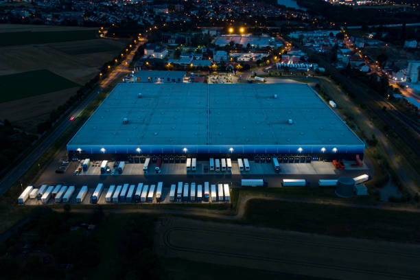 Loading bay, truck parking lot, industrial building, logistics - aerial view at night Loading bay, truck parking lot, industrial building, logistics - aerial view hubcap stock pictures, royalty-free photos & images