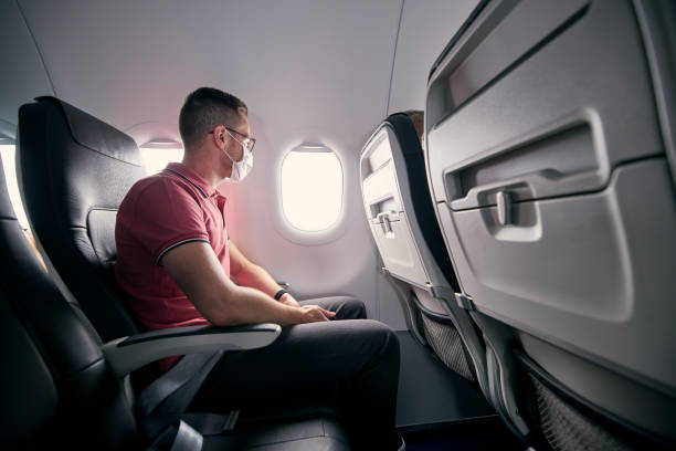 istock Passenger with protective face mask in airplane