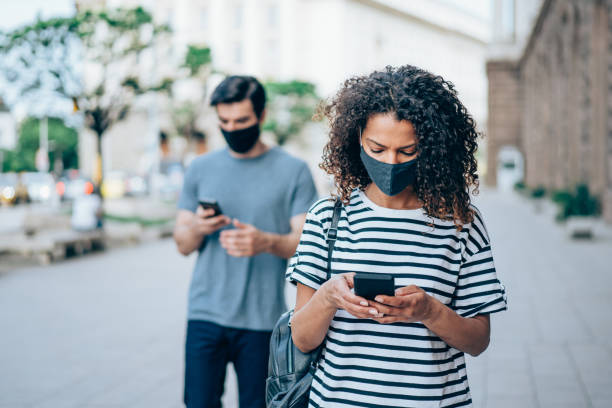 istock People with protective masks walking outdoors in the city. 1327248648
