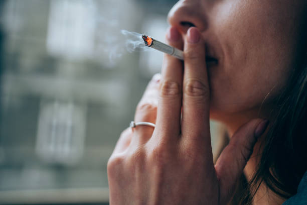 young woman smoking a cigarette outdoors. - smoking issues fotos imagens e fotografias de stock