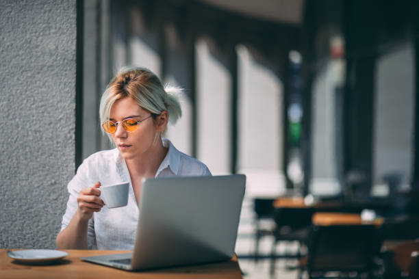 istock Young woman drinking coffee and checking email 1327249954