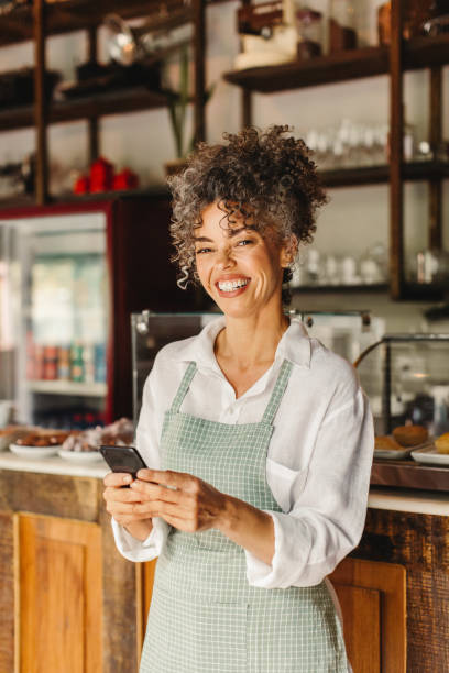 istock Business owner smiling while holding a smartphone 1327250710