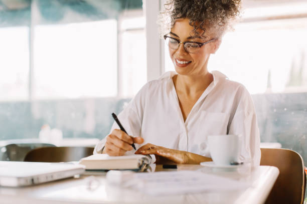 istock Happy businesswoman making notes in her journal 1327250712