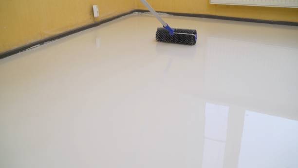 istock Worker rolls liquid floor. Needle roller for bulk floors. A worker fills the floor with a needle roller for bulk floors. Finishing work - the worker is filling the floor 1327252241