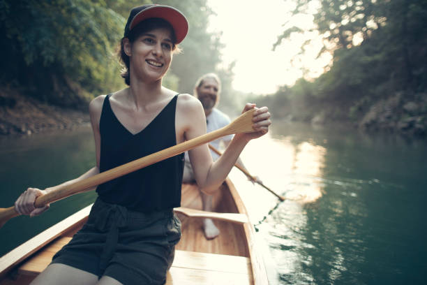 istock Smiling couple paddling canoe on a forest lake 1327254085