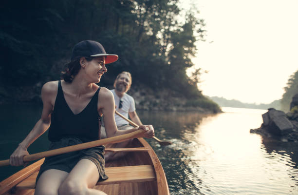 istock Smiling couple paddling canoe on a lake 1327254222