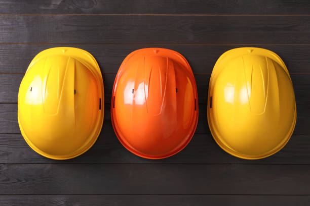 istock Different hard hats on wooden background, flat lay 1327255014
