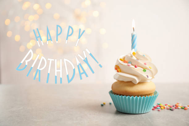 istock Happy Birthday! Delicious cupcake with candle on light background 1327255278