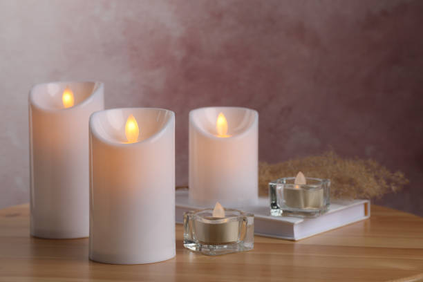istock Glowing decorative LED candles on wooden table 1327255307