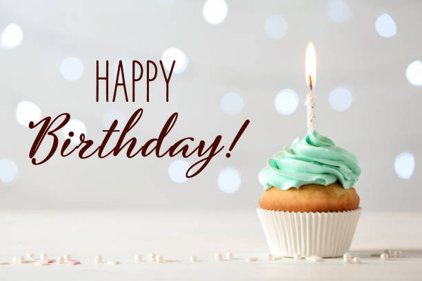 bon anniversaire! délicieux cupcake avec bougie allumée sur fond clair - anniversaire photos et images de collection