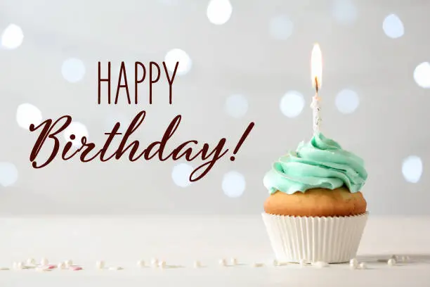 Photo of Happy Birthday! Delicious cupcake with burning candle on light background