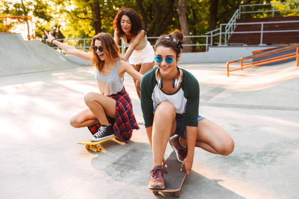 istock Three smiling young girls with skateboards 1327256013