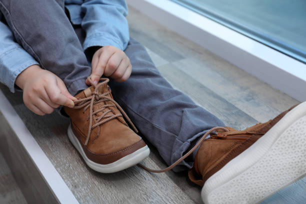 istock Little boy tying shoe laces at home, closeup 1327256094