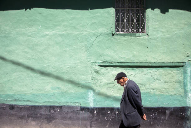 Unknown old man walking through an old house wall.Manisa,Turkey.21 April 2016