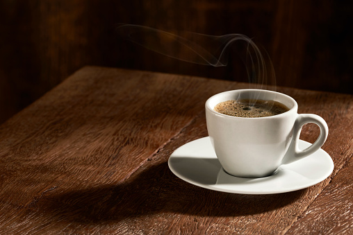 Isolated cup of coffee on rustic wooden background.