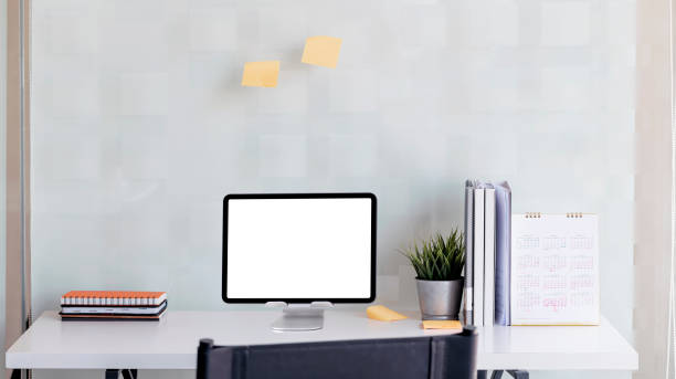 istock Portable office desk with mock-up tablet computer devices, supplies and decorations on white table, 1327258447