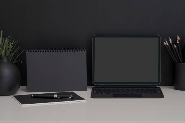 istock Mockup dark workspace with tablet with keyboard and supplies on white table and black background. 1327259817